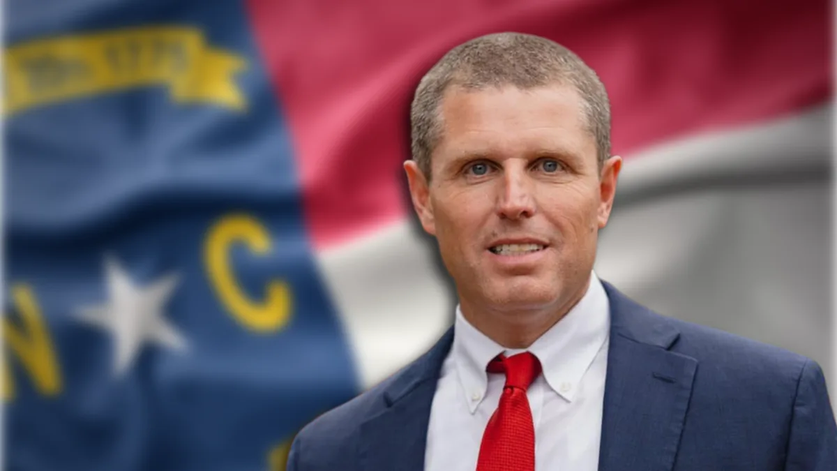 Portrait of Seth Woodall in front of a North Carolina flag